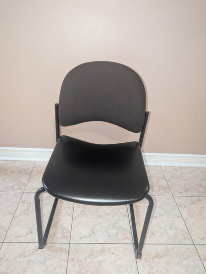 Black guest chair with fabric backrest and metal sled base, view 2