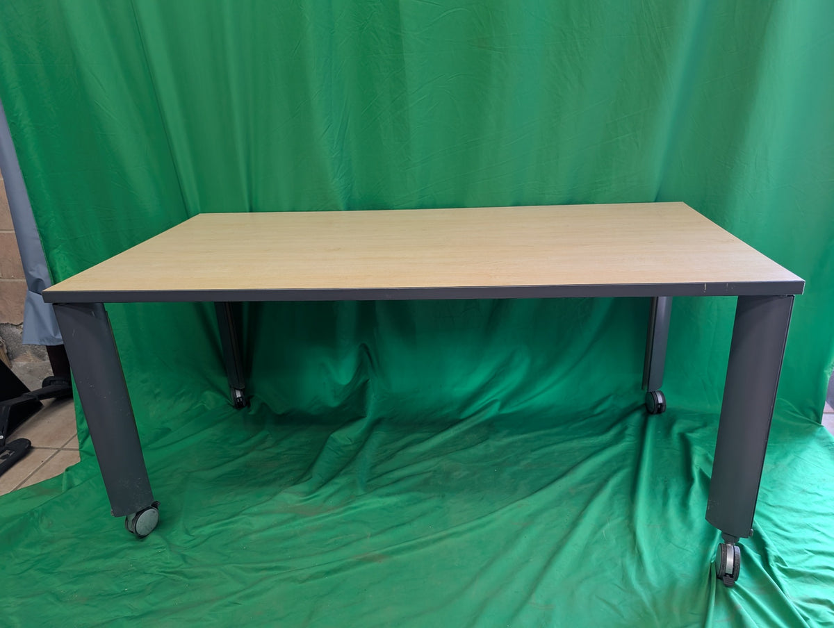 Woodgrain rectangular table with dark metal legs and casters, view 1