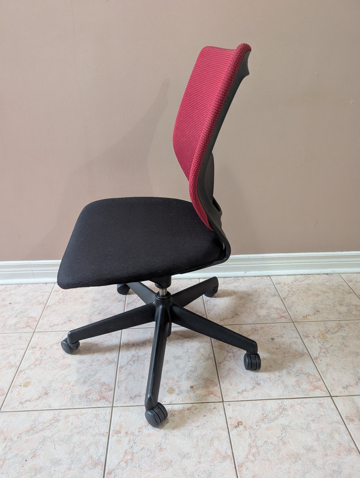 Red and black armless office chair side view