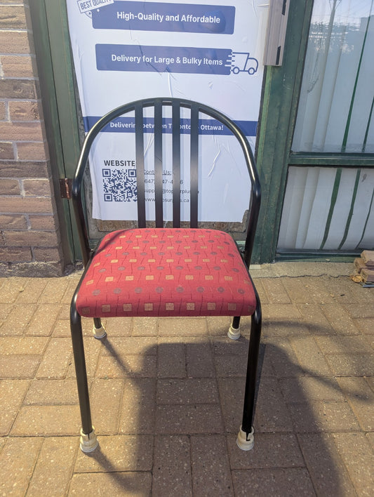 Red patterned upholstered stacking chair with black metal frame, front view