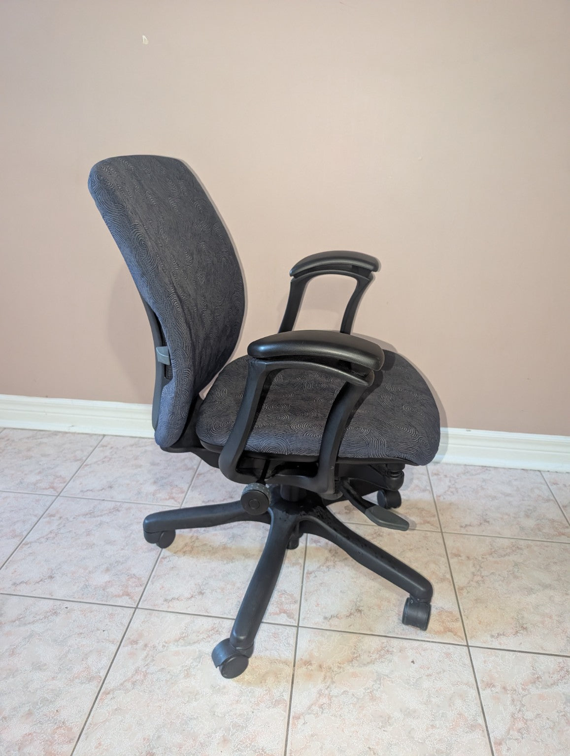 Teknion Amicus office chair with blue-grey patterned fabric, side view
