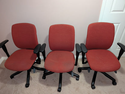 Red Teknion Amicus fabric office chair, group view showing condition variations
